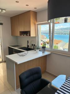 a kitchen with a counter and a large window at Apartments Salona in Trogir