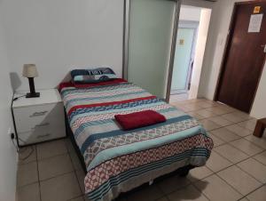 a bedroom with a bed with a quilt on it at Hunters Self Catering Apartment in East London