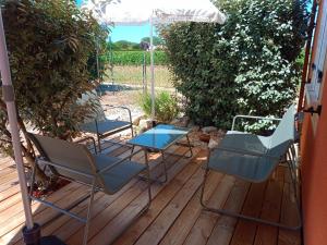 two chairs and a table on a deck with an umbrella at Au petit lieu-dit in Anglade