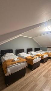 a group of four beds in a room at Kuzey Suite Otel in Uzungöl