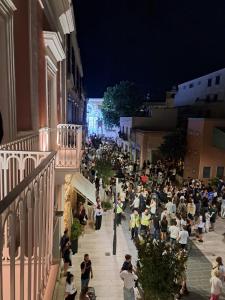 a crowd of people walking down a street at night at Antica Dimora Petito Luxury Suites in Matera