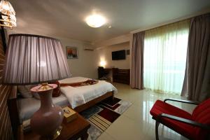 a hotel room with a bed and a table with a lamp at Aeroport Grand Hotel in Douala