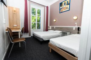 Hôtel Cesar Nîmes Centre Historique & Gare في نيم: غرفة بها سريران وطاولة وكرسي