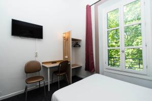 Hôtel Cesar Nîmes Centre Historique & Gare في نيم: غرفة بها سرير ومكتب ونافذة