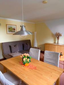 a dining room table with a vase of flowers on it at Haus Oberwiesenthal in Kurort Oberwiesenthal