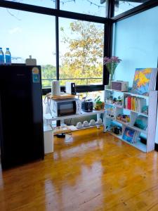 a room with a kitchen with a refrigerator and shelves at De Napa - Private Homestay in Ban Mae Na