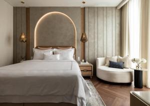 a bedroom with a large white bed and a chair at Hotel Fairmounts Plaza Near IGI International Airport Delhi in New Delhi