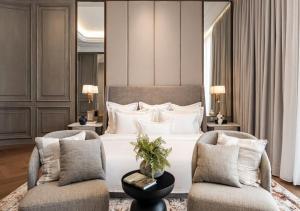 a bedroom with a large bed and two chairs at Hotel Fairmounts Plaza Near IGI International Airport Delhi in New Delhi