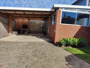 a brick house with a pavilion on a patio at Hunters Self Catering Apartment in East London