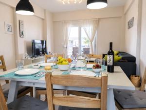 a dining room with a table with a bottle of wine at Lagonisi Apartment in Skála Nikíta +15 photos