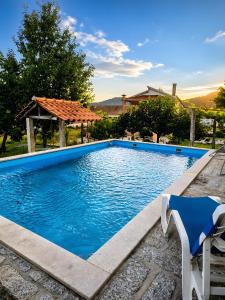 a blue swimming pool with a chair and a gazebo at Quinta do Passal - Gondoriz in Gondoriz