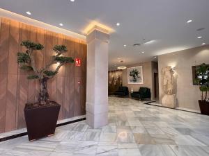 eine Lobby mit einem Baum in der Mitte eines Gebäudes in der Unterkunft Hotel Nova Roma in Merida + 6 Fotos