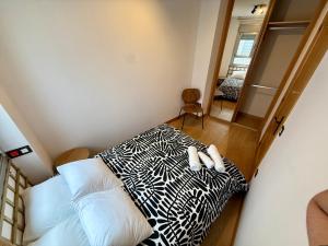 a bedroom with a black and white bed and a mirror at Lotila Flats Oviedo in Oviedo