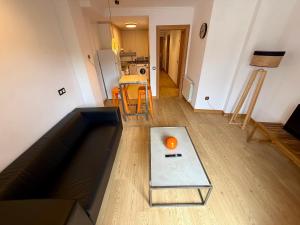 a living room with a couch and an orange on a table at Lotila Flats Oviedo in Oviedo