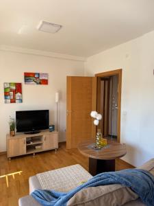 a living room with a tv and a table at Apartman Lambros 2 in Soko Banja