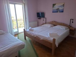 a bedroom with two beds and a large window at Apartma Z in Koper