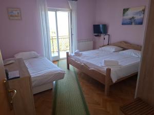 two beds in a small room with a window at Apartma Z in Koper