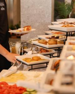a row of plates of food on a buffet at Hotel Fairmounts Plaza Near IGI International Airport Delhi in New Delhi