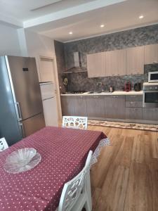 a kitchen with a table with a purple table cloth at Rosmat's house in Conversano