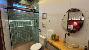 a bathroom with a sink and a toilet and a mirror at Pousada O Canto do Francês in Soure