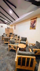 a room filled with wooden chairs and tables at Enjipai Ngorongoro Lodge in Karatu