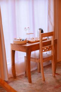 a wooden table with a chair next to a window at Enjipai Ngorongoro Lodge in Karatu