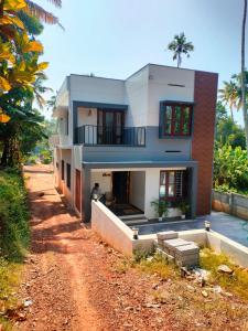 a house on the side of a dirt road at Kodikkakkam Homestay in Kappil