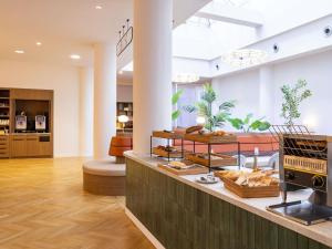 eine Bäckerei mit einer Theke mit Brot und Gebäck in der Unterkunft Mercure Brussels Centre Rogier in Brüssel + 65 Fotos