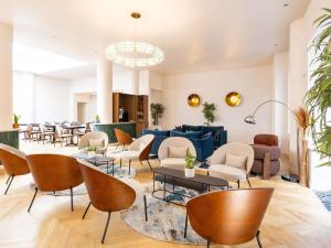 eine Lobby mit Sofas, Tischen und Stühlen in der Unterkunft Mercure Brussels Centre Rogier in Brüssel
