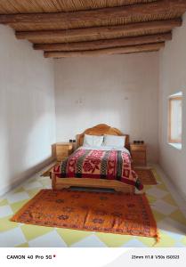 a bedroom with a bed and a rug on the floor at Riad tinghir in Tinerhir