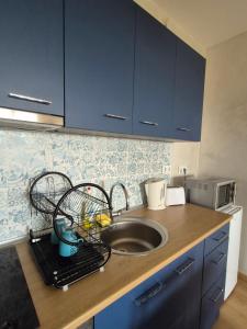a kitchen with blue cabinets and a sink and a counter at Seaside Dream in Dolen Bliznak