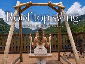 a girl sitting on a swing on a deck at Nakao Kogen Hotel Kazaguruma in Takayama
