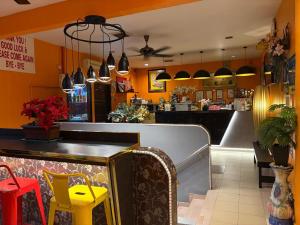 a restaurant with a bar with yellow chairs and a counter at Weng Kong Hotel in Slim River +56 photos