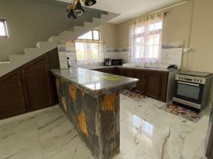 a kitchen with a marble counter top and stairs at villa POOJA in Cap Malheureux