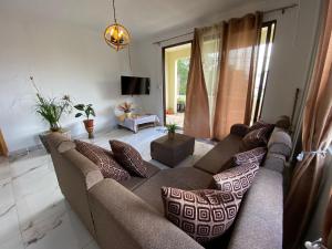 a living room with a couch with pillows at villa POOJA in Cap Malheureux