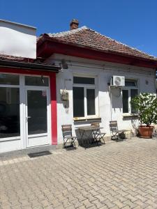 a house with chairs and a table in front of it at Twin-Tam House in Timişoara