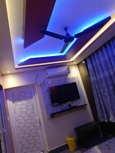 a room with a ceiling fan and a flat screen tv at Hotel Malik Palace in Noāmundi