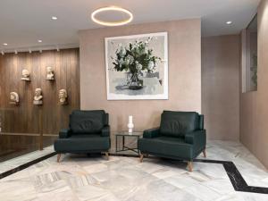 Eine Lobby mit zwei Stühlen und einer Blumenvase in der Unterkunft Hotel Nova Roma in Merida