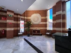 eine Lobby mit Stühlen und Kamin in einem Gebäude in der Unterkunft Hotel Nova Roma in Merida