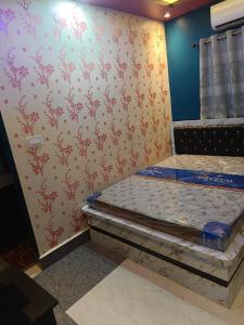 a bedroom with two beds in a room with wallpaper at Hotel Malik Palace in Noāmundi