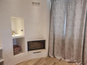 a living room with a television and a curtain at Rosmat's house in Conversano