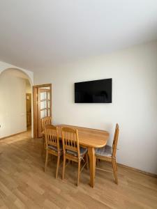 a dining room with a wooden table and chairs at Apartment Jūros Mėlis in Nida