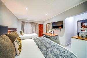 a hotel room with a bed and a desk at 13 Hobson in Secunda