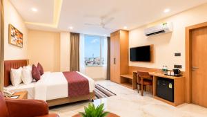 a hotel room with a bed and a desk at Vaishnavi Beacon Hotel Patna in Patna