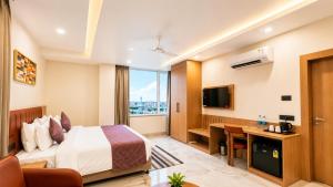 a hotel room with a bed and a desk at Vaishnavi Beacon Hotel Patna in Patna +20 photos