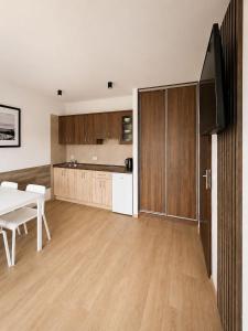 a kitchen and living room with a table and a television at Rowyhills in Rowy
