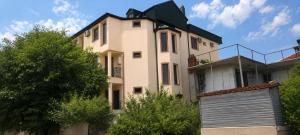 a large white house with a gate in front of it at Guramishvili 7 in Kobuleti