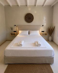 a bedroom with a large white bed with towels on it at Dryope Luxury Living in Dhriopís