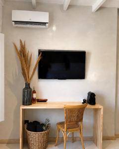 a room with a desk and a television on a wall at Dryope Luxury Living in Dhriopís