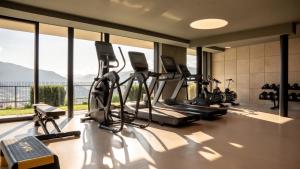 ein Fitnessstudio mit Cardiogeräten und einem großen Fenster in der Unterkunft Panoramahotel Watles in Mals im Vinschgau